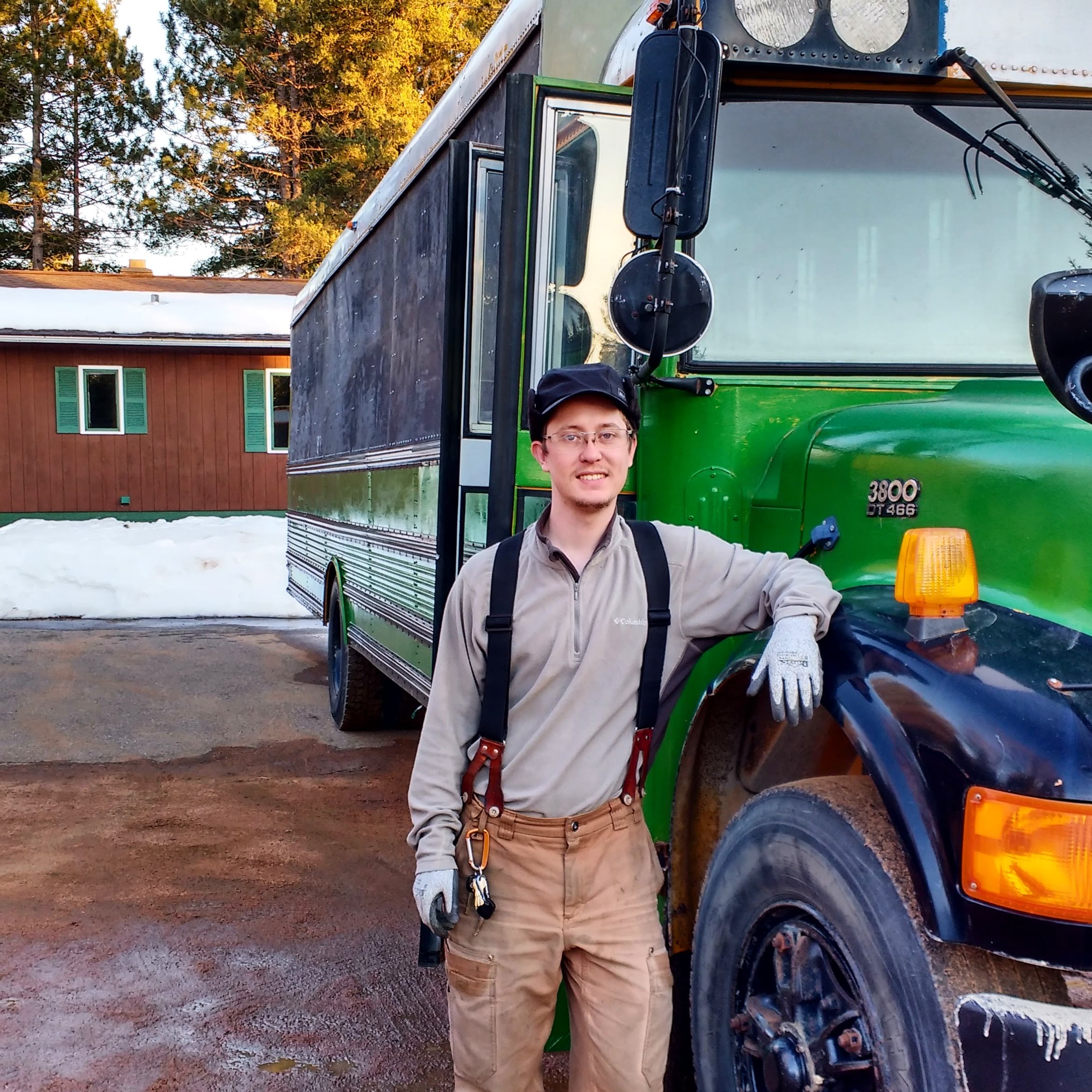 Nick standing in front of Toad, the green school bus, in front of our Rhinelander property